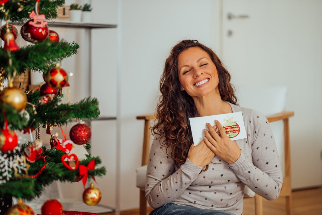 Femme qui tient une carte du temps des fêtes