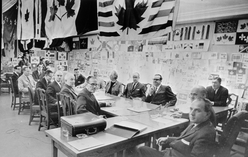 Members of the Commons flag committee are surrounded by 1,200 designs for a new Canadian flag which they are considering.