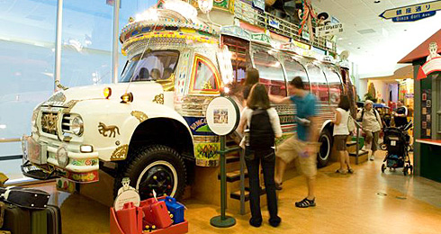 A historic bus on display in an airport's History Hall.