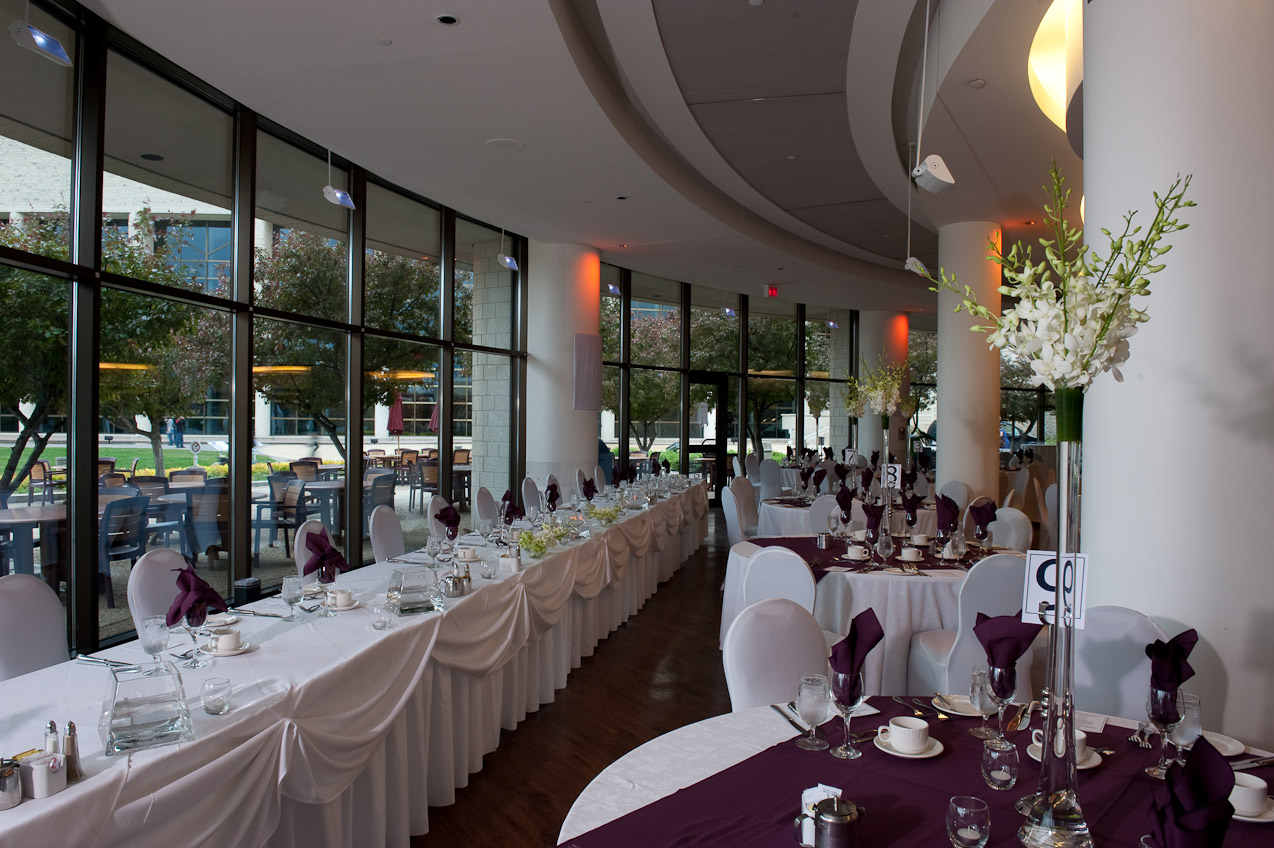 A large room with tables and chairs set up for a wedding.