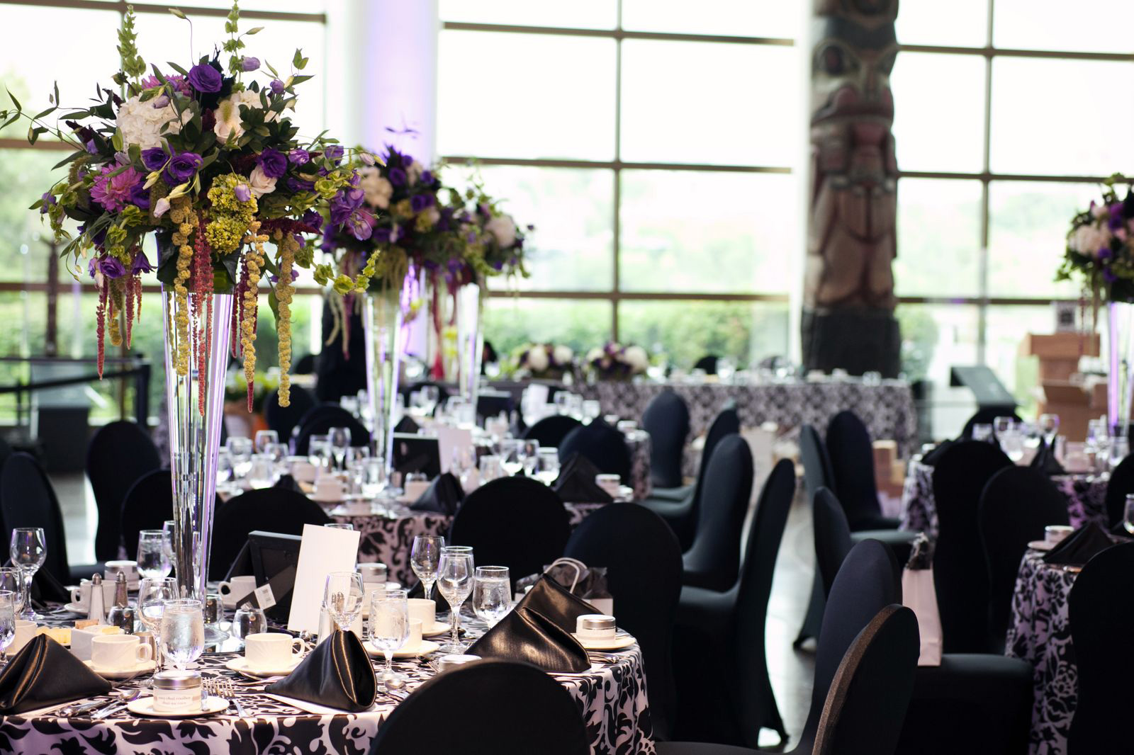 A black and white wedding reception with purple flowers, offering facility rental options.