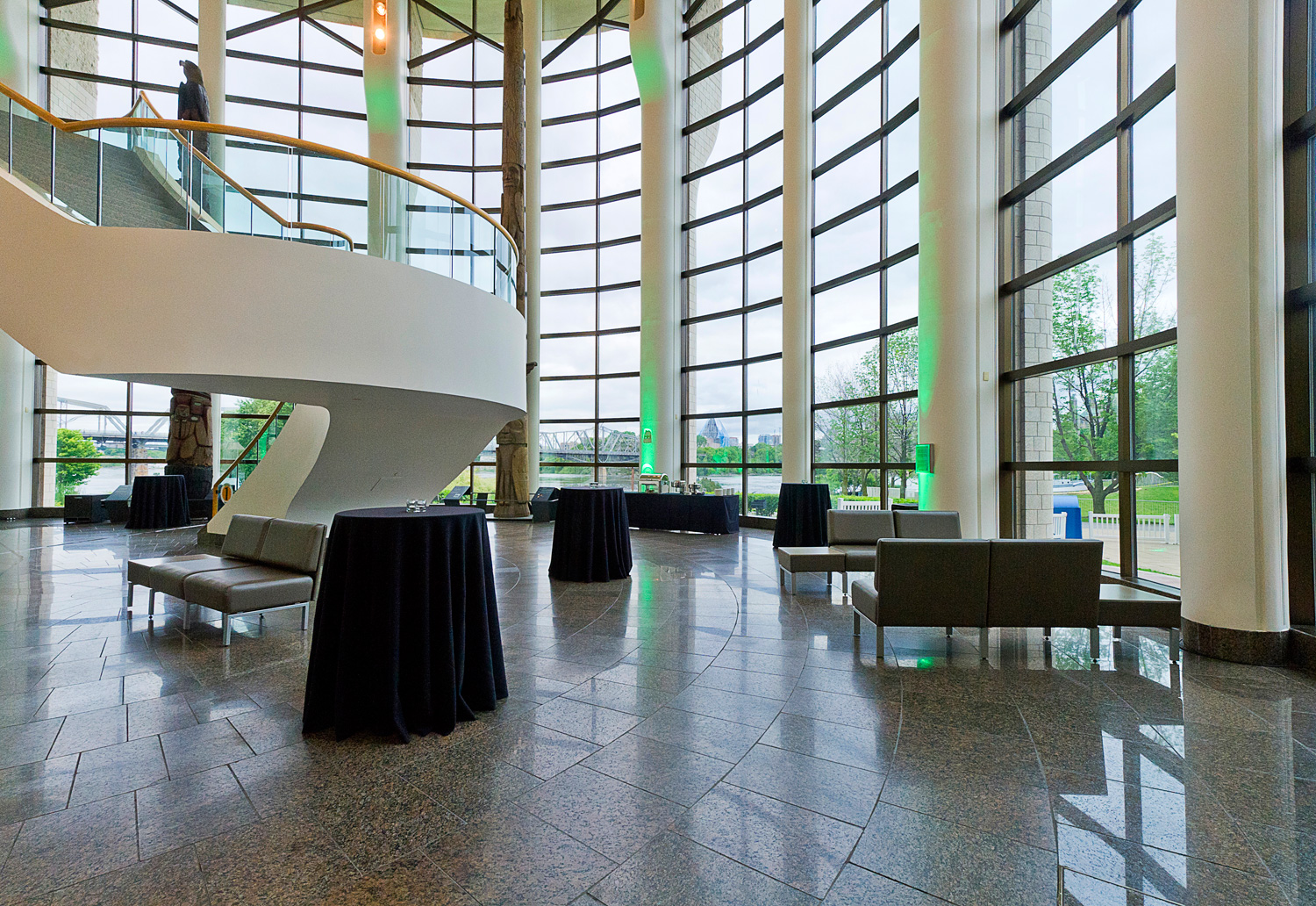 A grand salon with a spiral staircase and large windows, perfect for hosting celebrations on the beautiful Haida Gwaii.