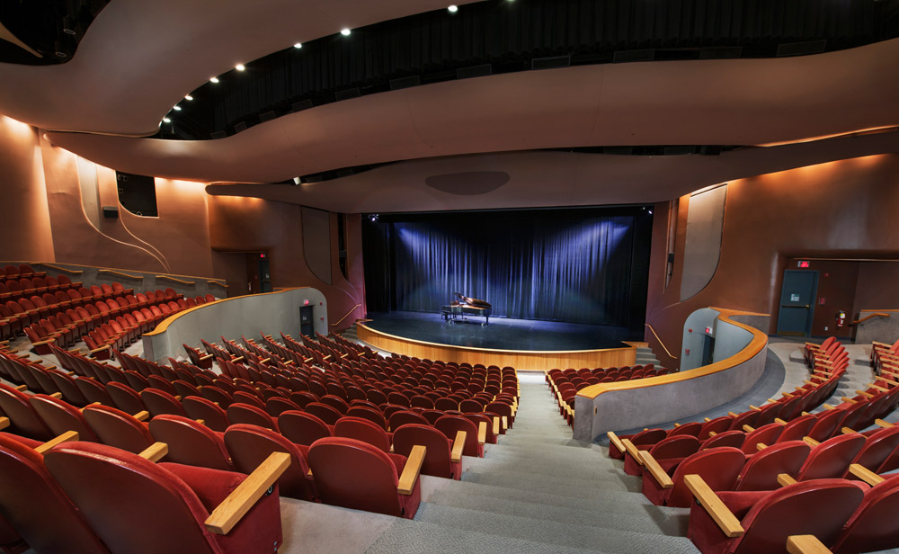 The Canadian Museum of History, located in Ottawa, features an auditorium with red seats and a piano.