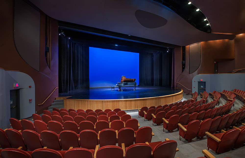 An auditorium with red chairs and a piano in the Canadian Museum of History.