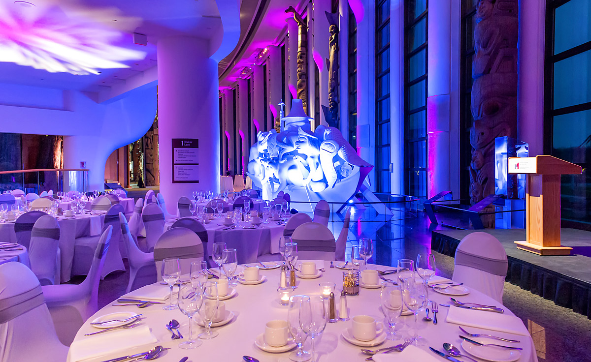 A large room with tables and chairs set up for an event, located in the Canadian Museum of History in Ottawa.