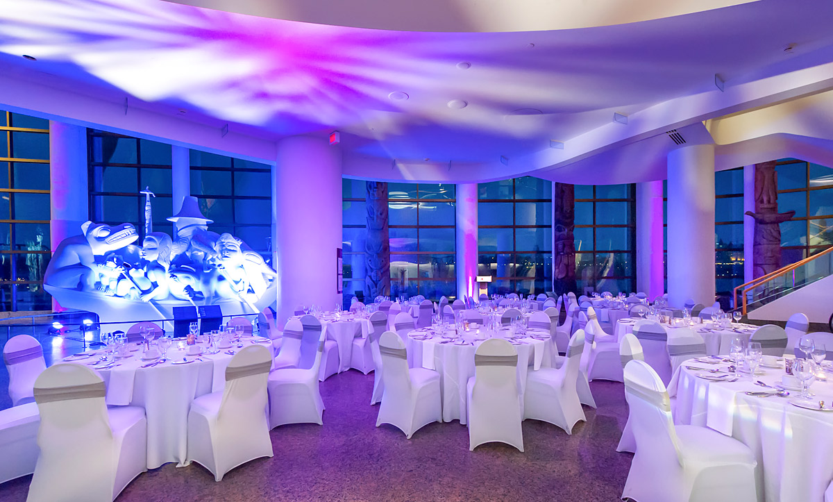 In the Canadian Museum of History in Ottawa, a large room with tables and chairs is elegantly set up for a wedding.