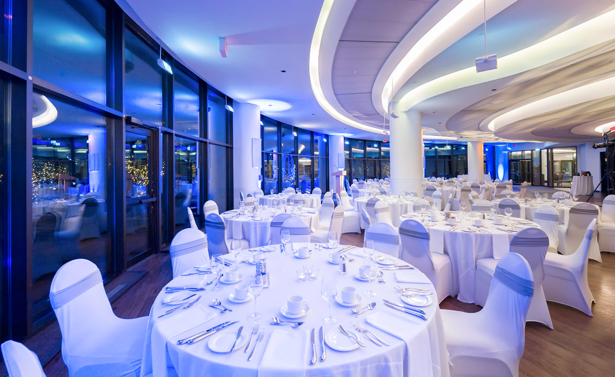 A large banquet hall with white tables and chairs located in Ottawa within the Canadian Museum of History.