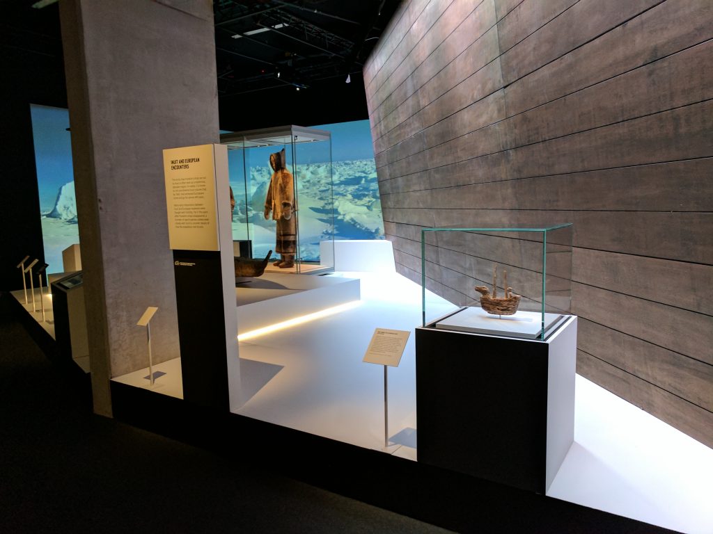 The introductory area of Death in the Ice at the National Maritime Museum includes an Inuit carving of a European ship (foreground). Photo: Canadian Museum of History.