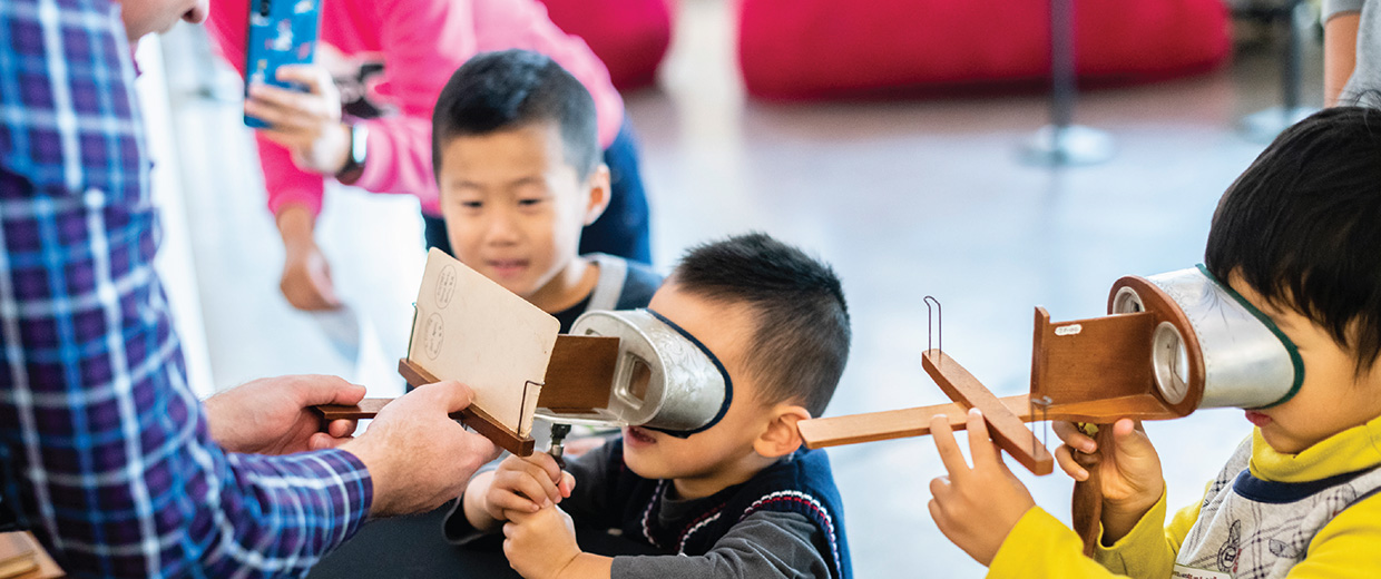 At the Canadian Museum of History in Ottawa, a group of children are playing with a pair of binoculars.