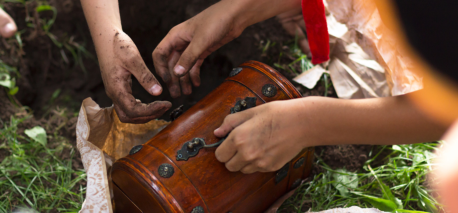 A person is putting a suitcase in the dirt at the Canadian Museum of History.