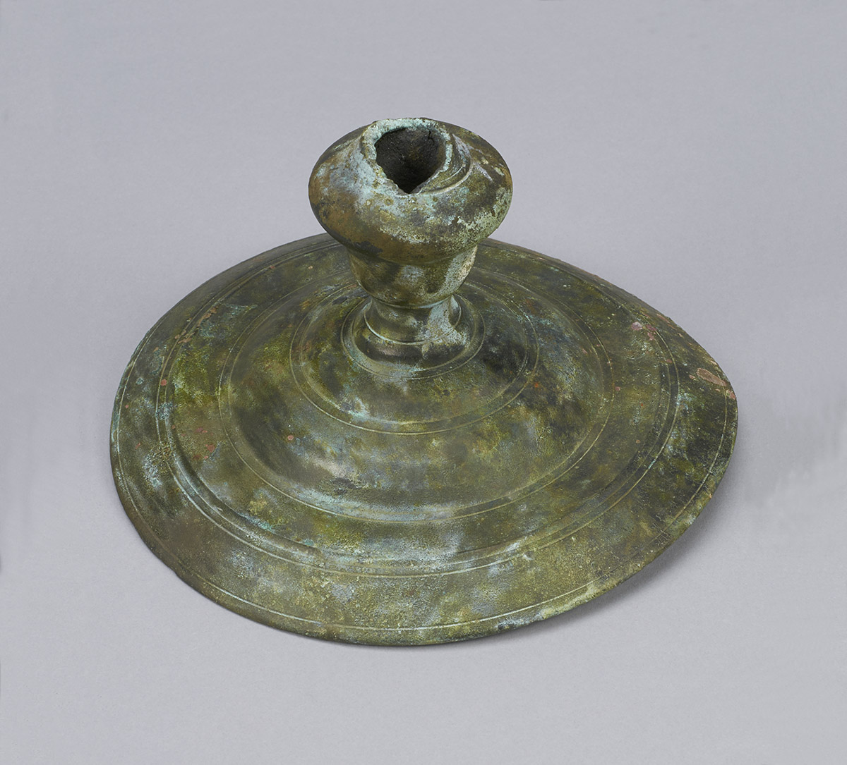 A bronze candle holder on a gray surface at the Canadian Museum of History in Ottawa.