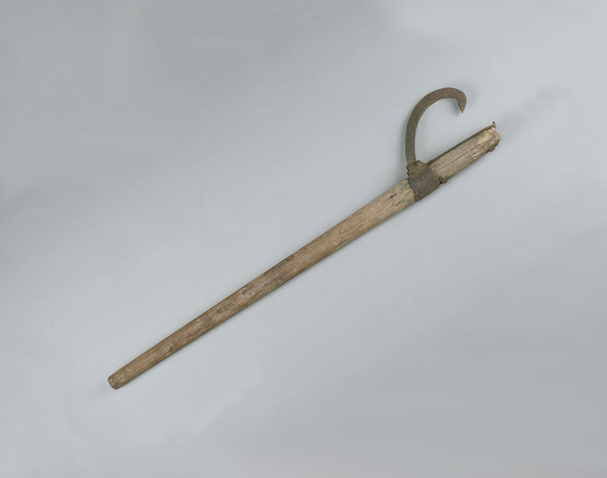 A wooden stick with a handle, displayed at the Canadian Museum of History in Ottawa, on a white surface.