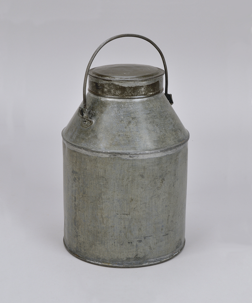 A metal milk jug on a white background at the Canadian Museum of History in Ottawa.