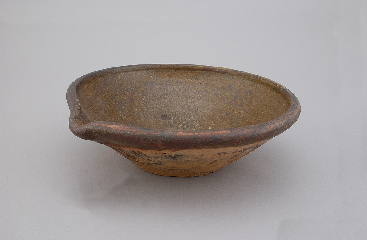 A small bowl with a brown glaze displayed at the Canadian Museum of History in Ottawa.