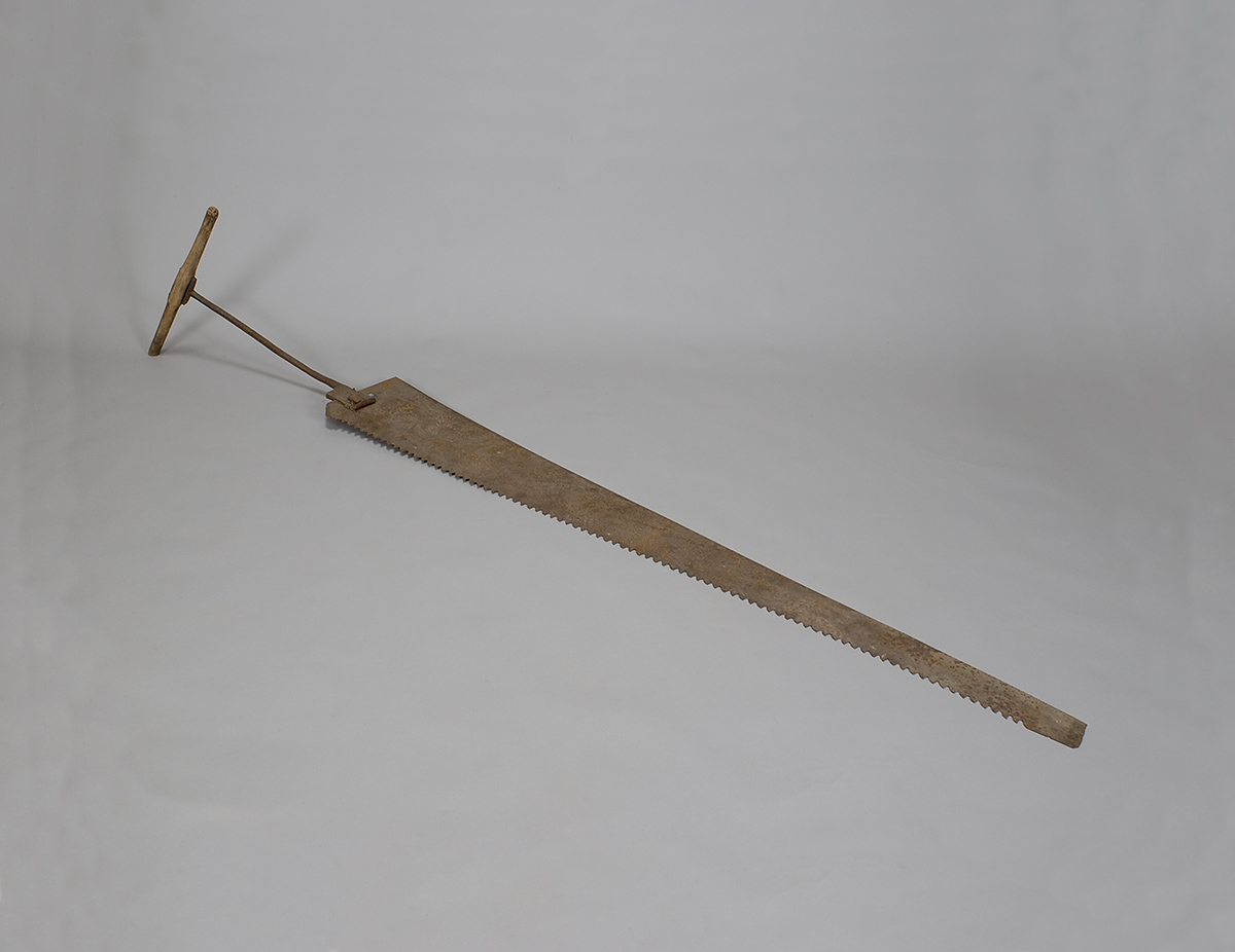 A wooden tool with a wooden handle on a white surface at the Canadian Museum of History.