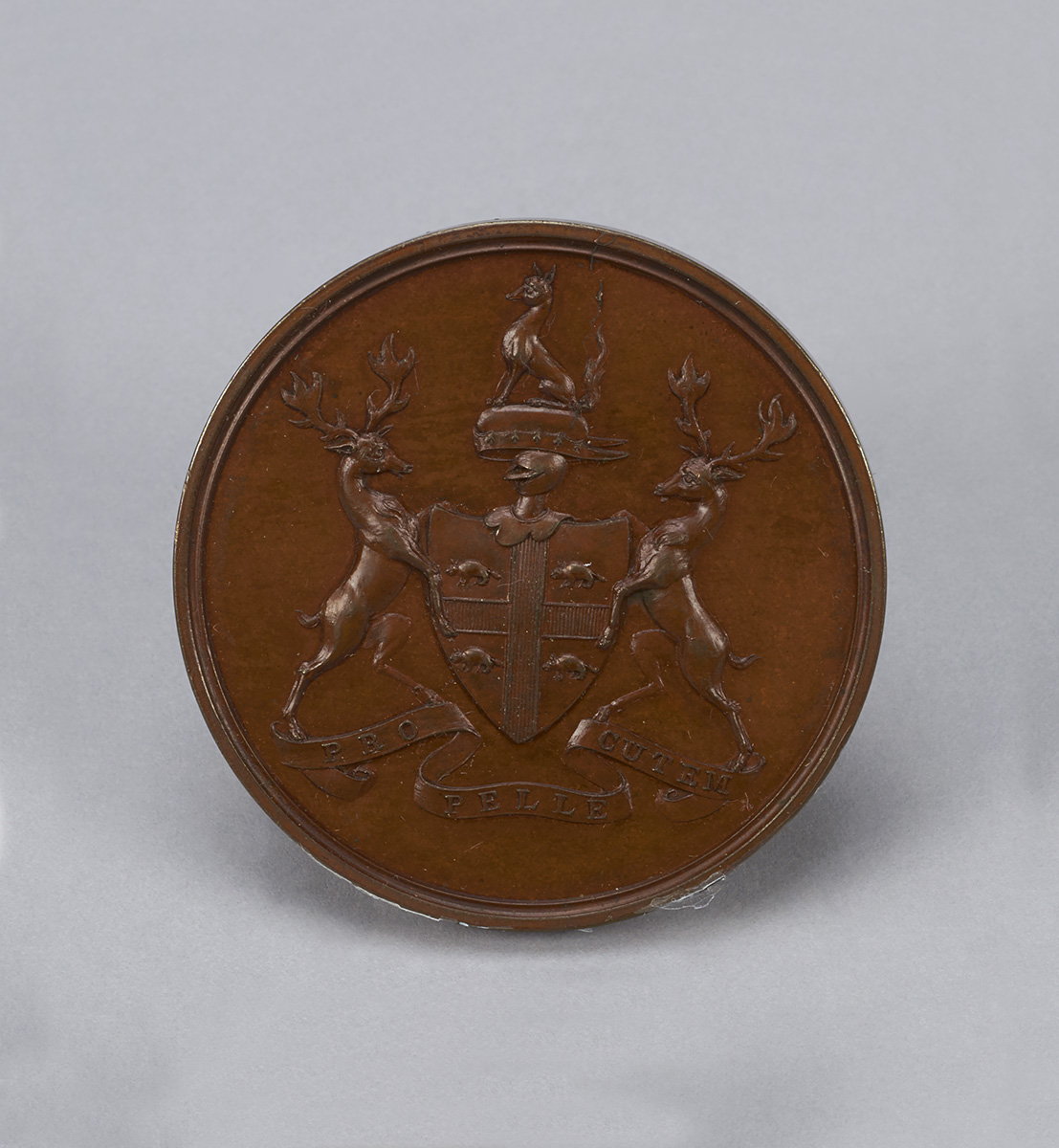 A bronze medal with a coat of arms on it displayed at the Canadian Museum of History in Ottawa.