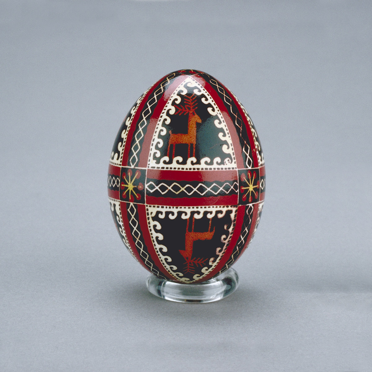 A red and black painted egg on a gray background at the Canadian Museum of History in Ottawa.