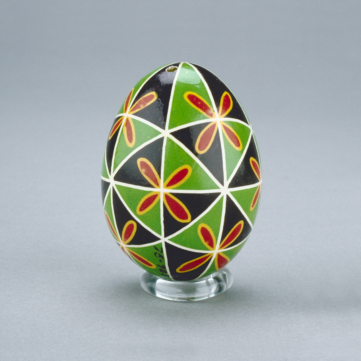 A green and black egg with a geometric design, displayed at the Canadian Museum of History in Ottawa.