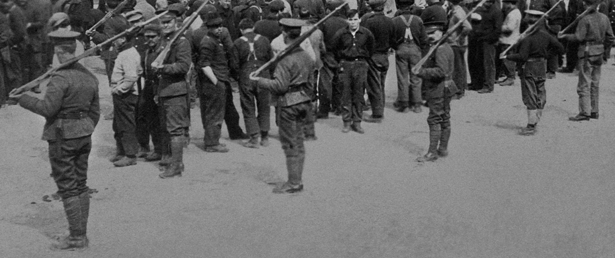 A group of men standing in a line with rifles at the Canadian Museum of History.