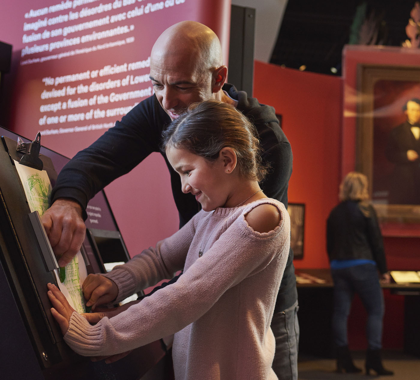 A man and a girl looking at a display at the Canadian Museum of History in Ottawa.