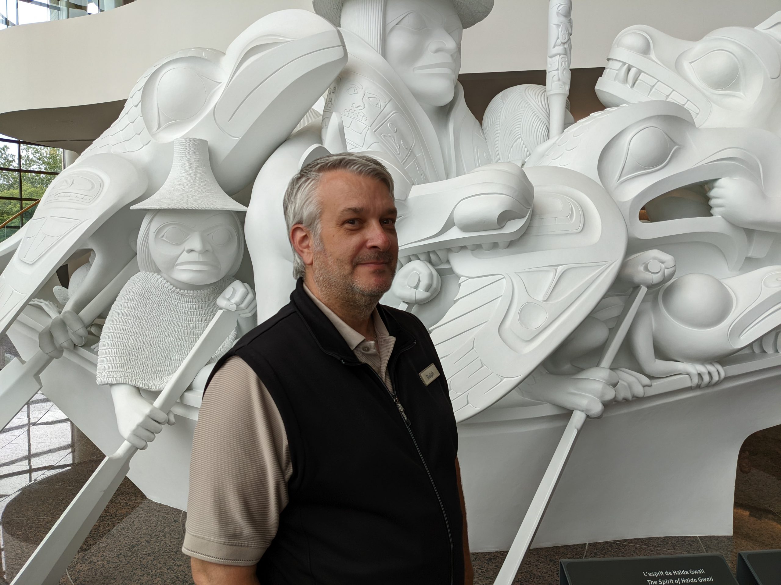 A man standing in front of a large white sculpture at the Canadian Museum of History in Ottawa.