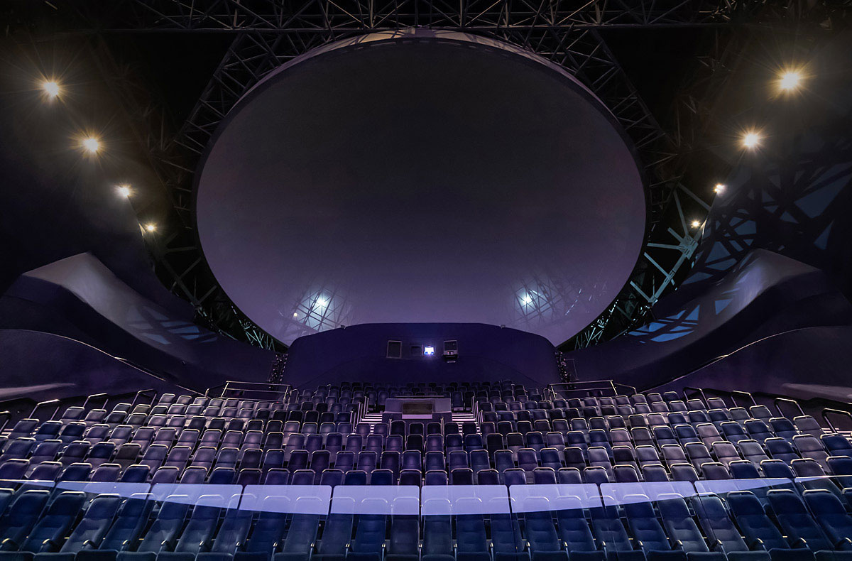 An auditorium with blue chairs, offering facility rental options.