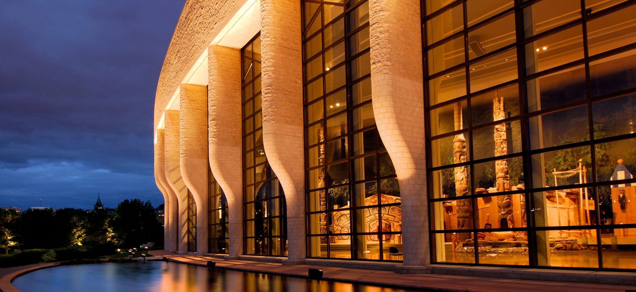 In Ottawa, the Canadian Museum of History stands tall with large windows and a water feature at night.