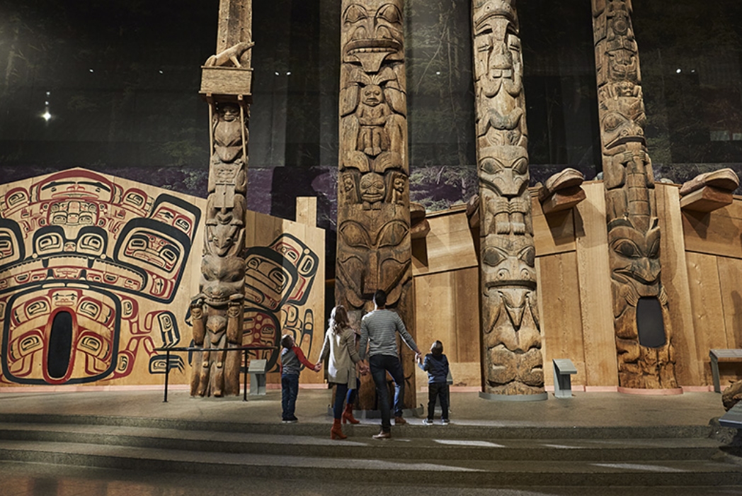 A group of people standing in front of totem poles at the Canadian Museum of History in Ottawa.