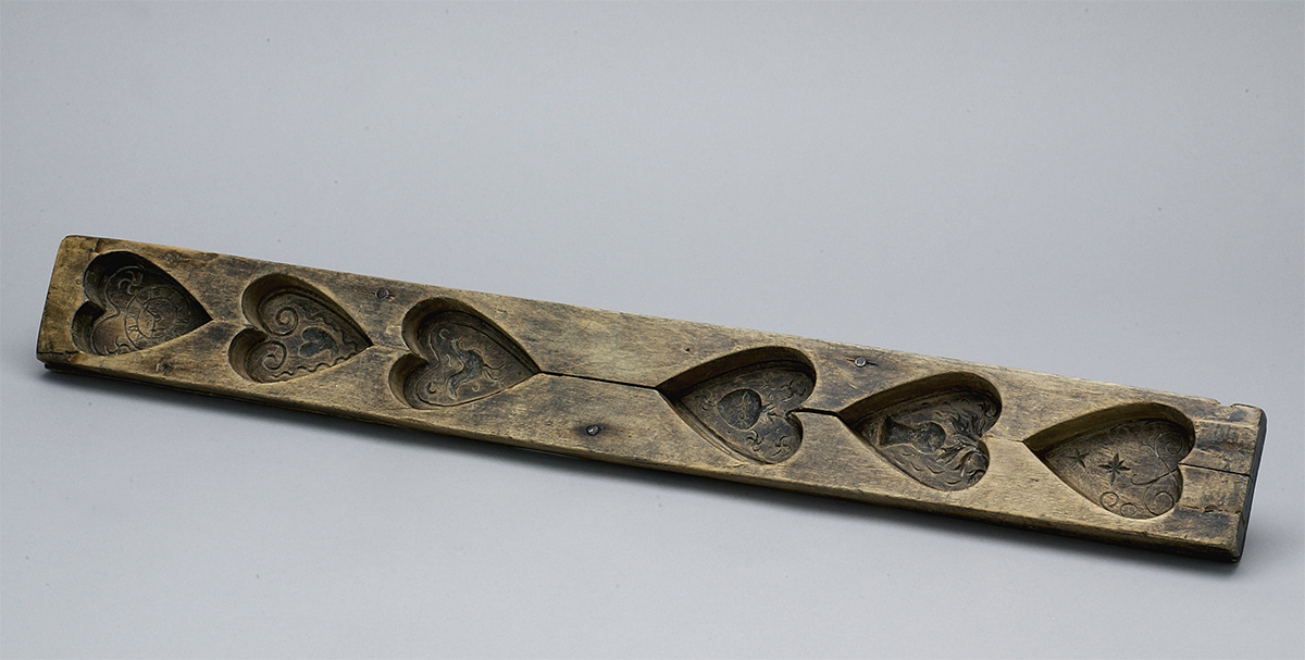 A wooden heart-shaped tray on a white surface in Ottawa at the Canadian Museum of History.