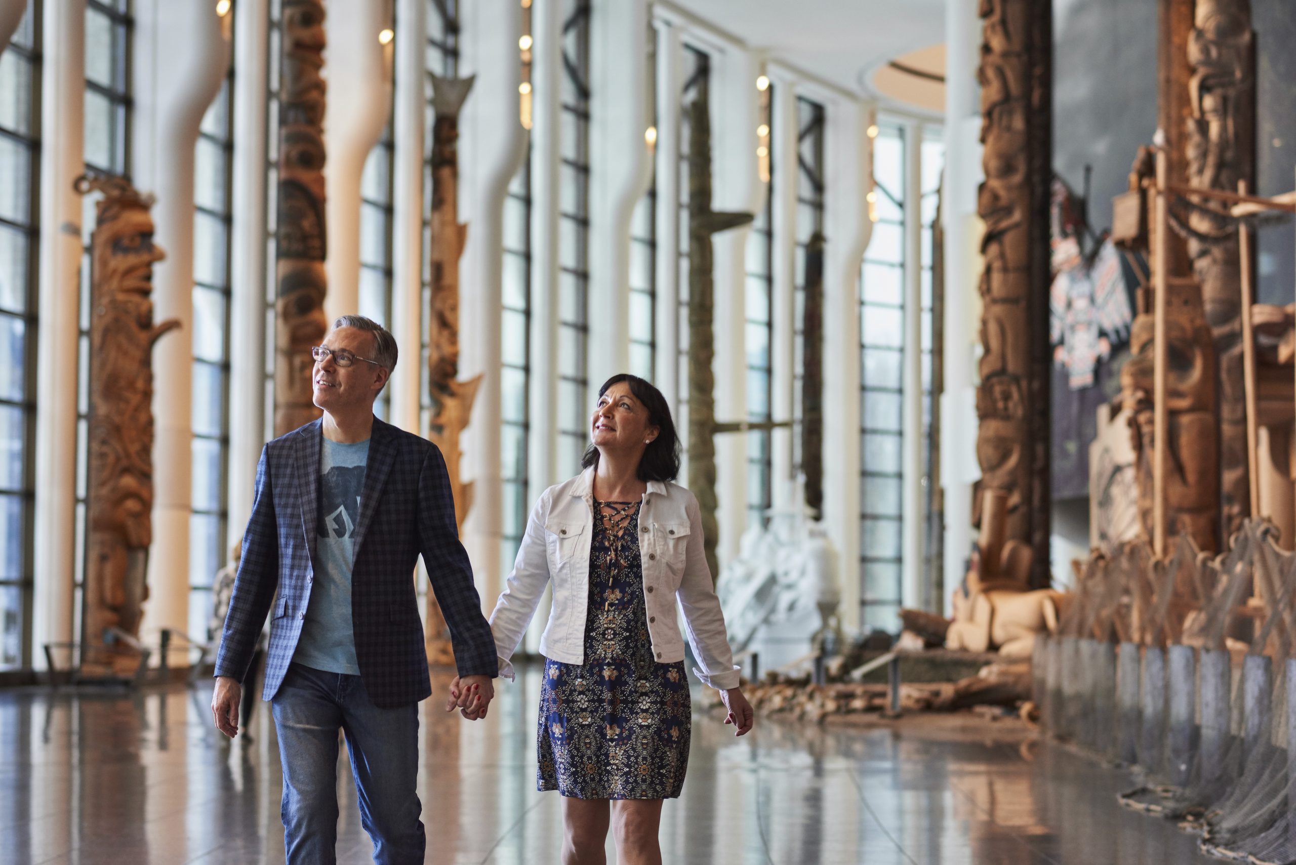 A couple visiting the Canadian Museum of History in Ottawa, admiring large sculptures as they walk through the exhibits.