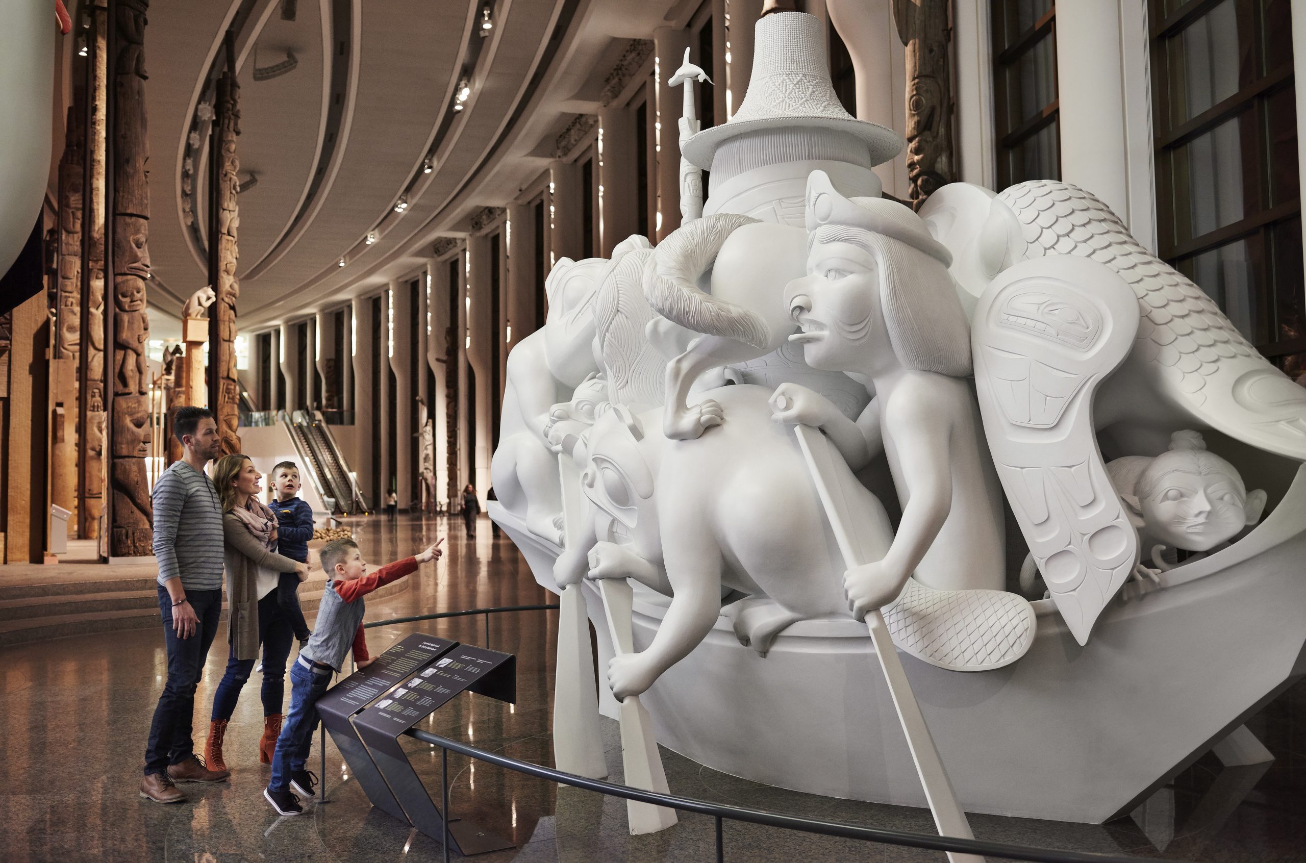 A group of people in Ottawa, visiting the Canadian Museum of History, are captivated by a sculpture.