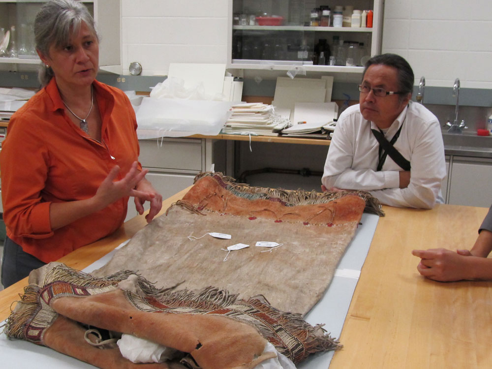 Two people standing around a table, reviewing an artifact at the Canadian Museum of History in Ottawa.