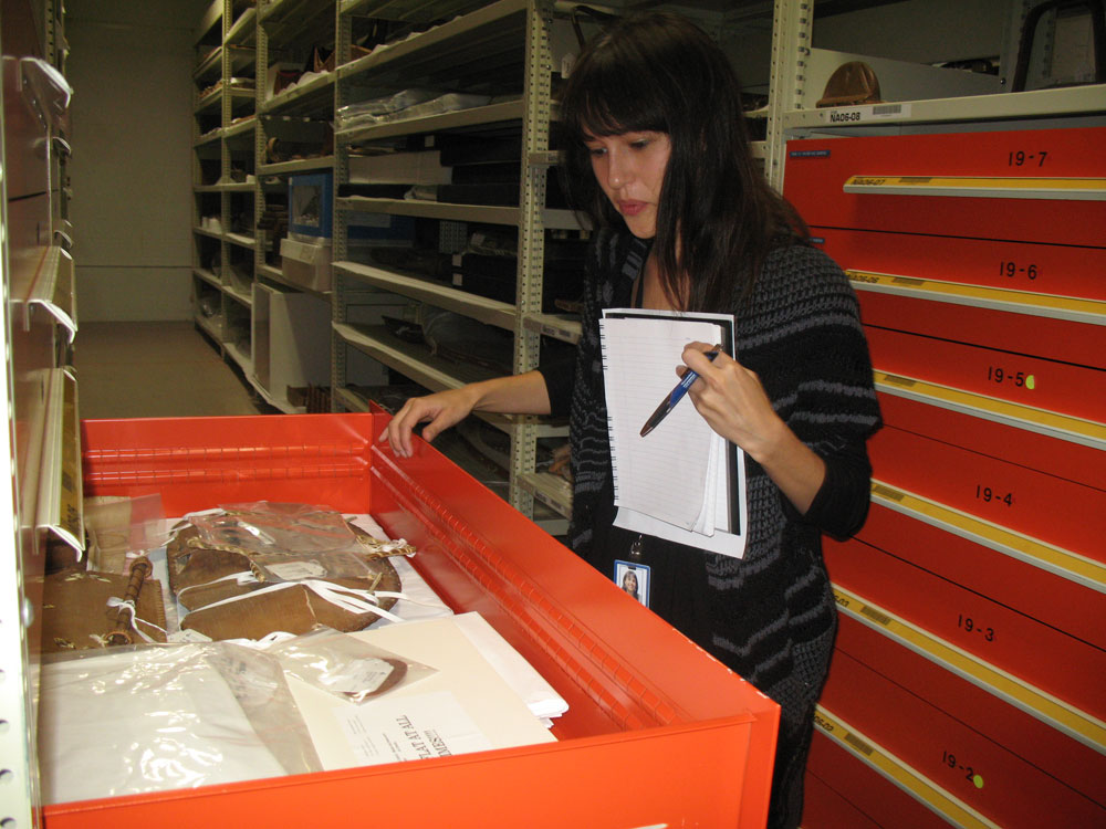 A woman looking at a box of artifacts in the Canadian Museum of History.