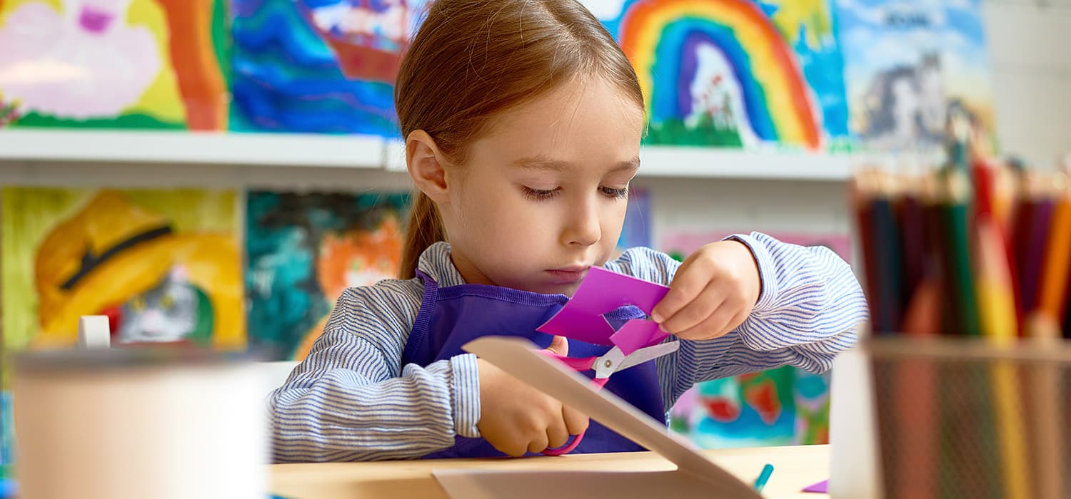 A young girl is working on a piece of paper at the Canadian Museum of History.