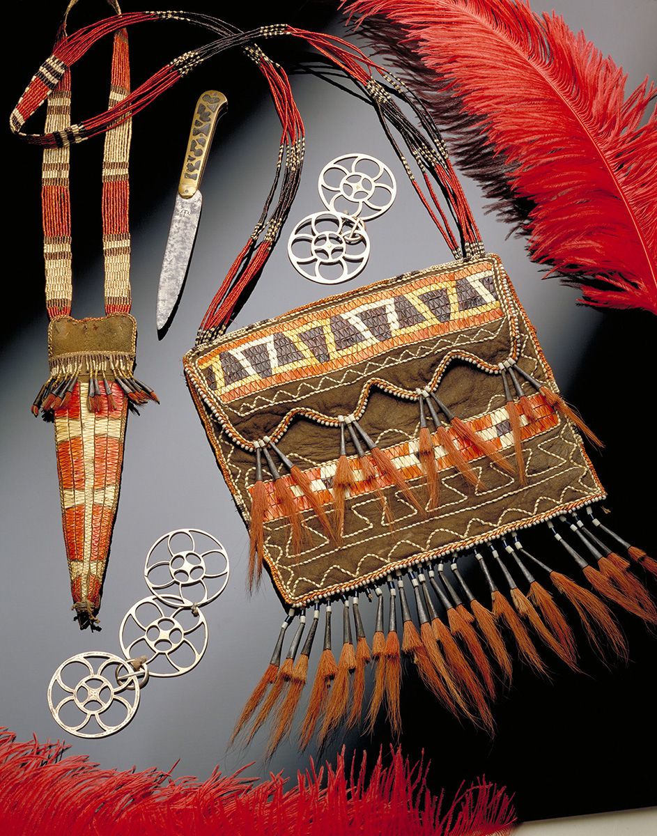 A feathered purse with a knife on a black surface displayed at the Canadian Museum of History in Ottawa.