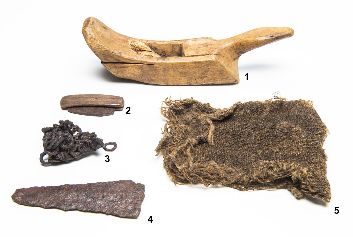 A wooden boat and other items on a white surface at the Canadian Museum of History in Ottawa.