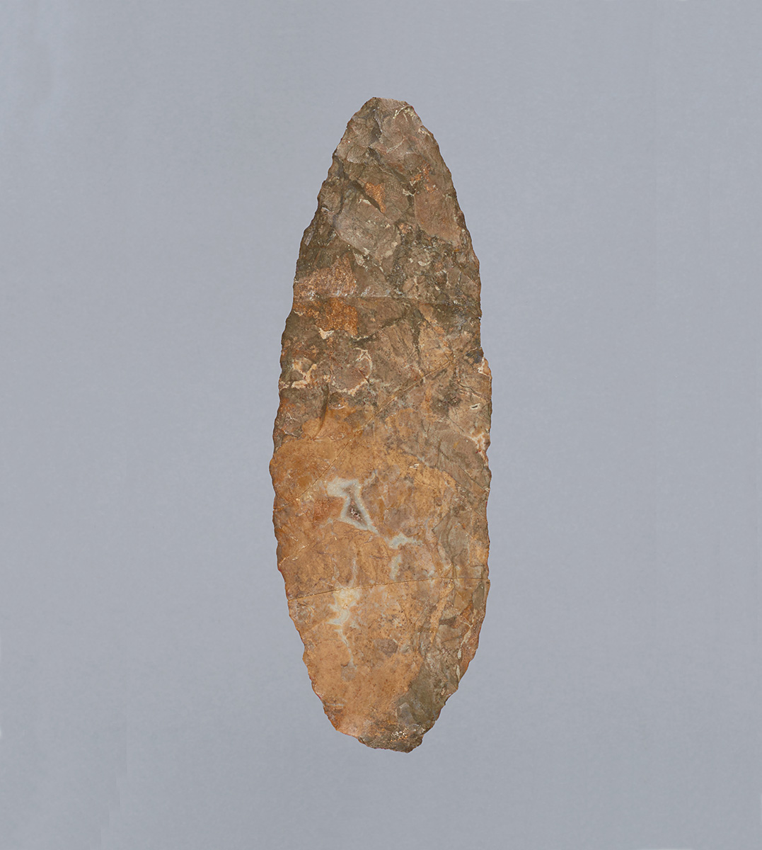 A stone arrowhead on a gray background at the Canadian Museum of History in Ottawa.