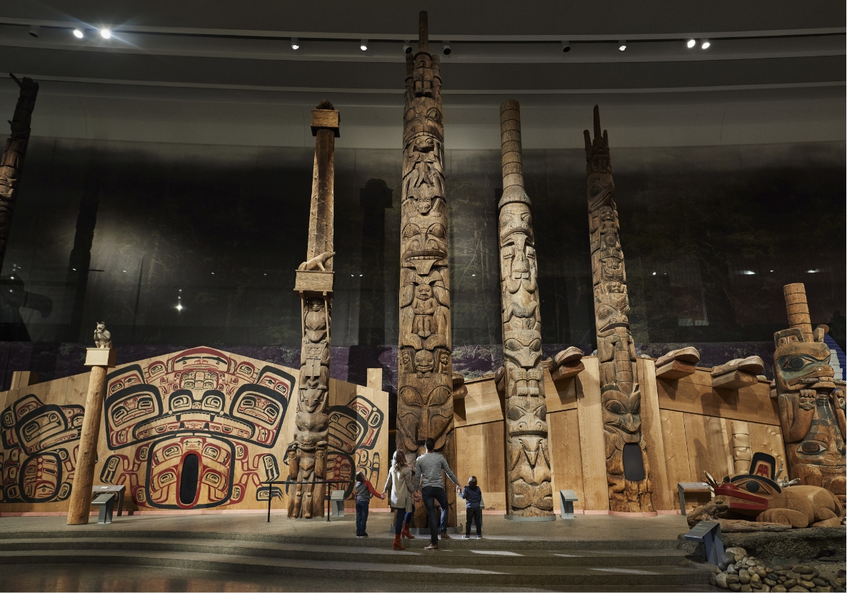 Family of four looking at totem poles