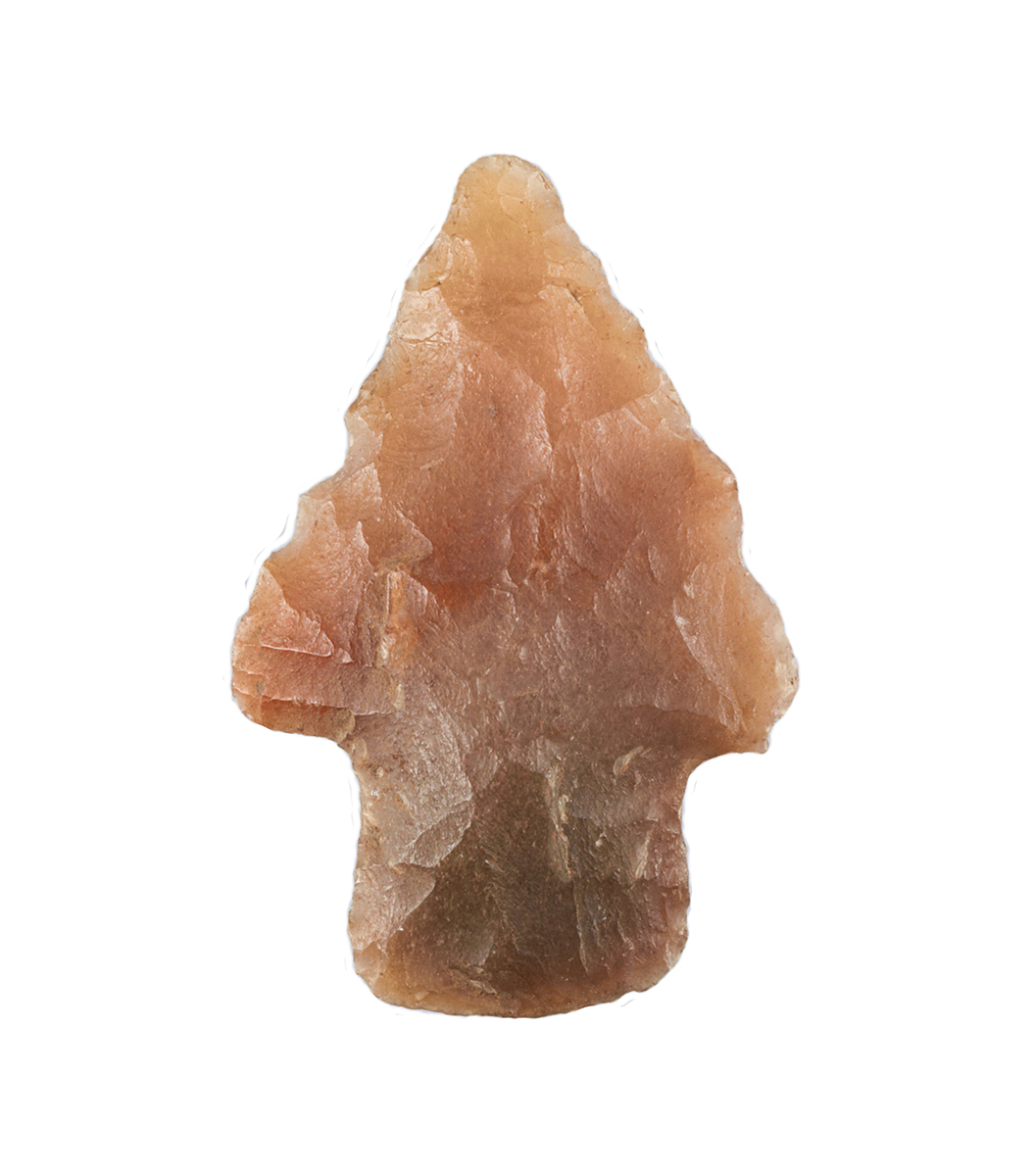 A small stone arrowhead on a white background displayed at the Canadian Museum of History in Ottawa.