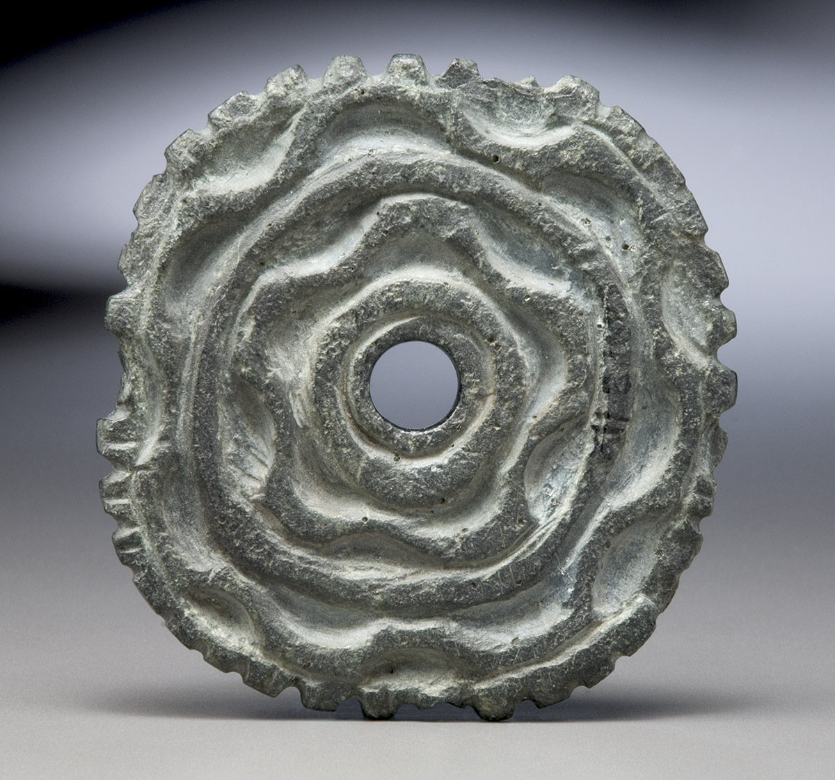 A circular piece of metal with a hole in the middle on display at the Canadian Museum of History in Ottawa.