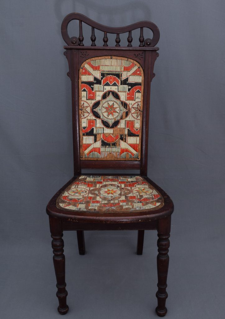 An ornate wooden chair with an upholstered seat.