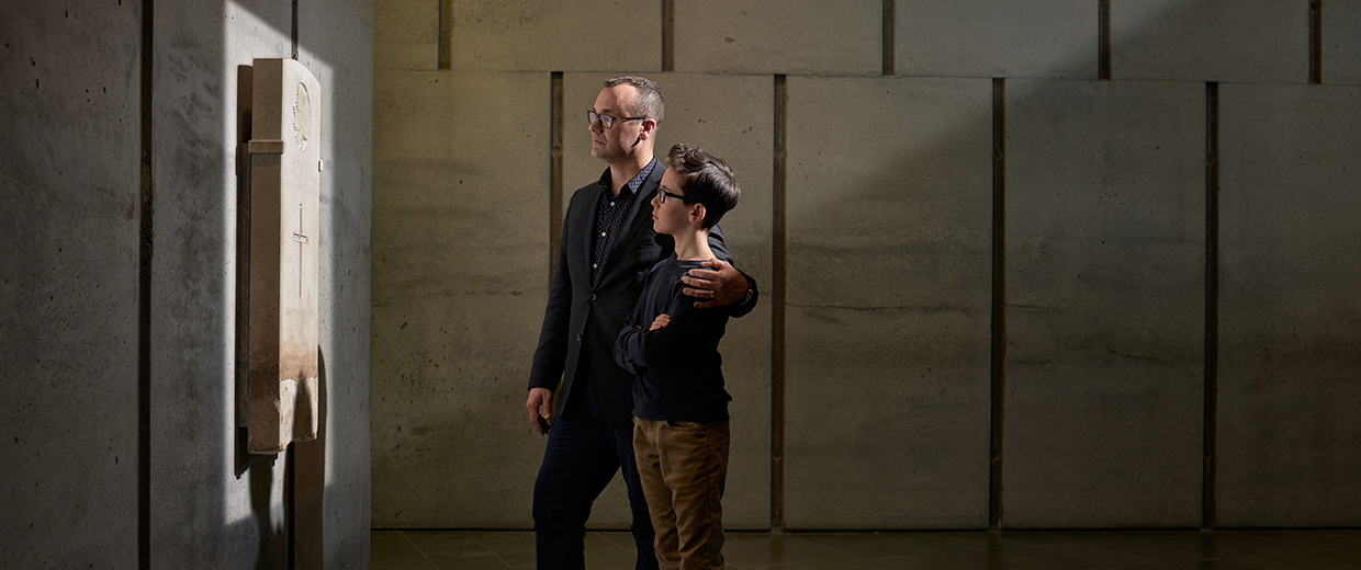 A couple standing in front of a wall.