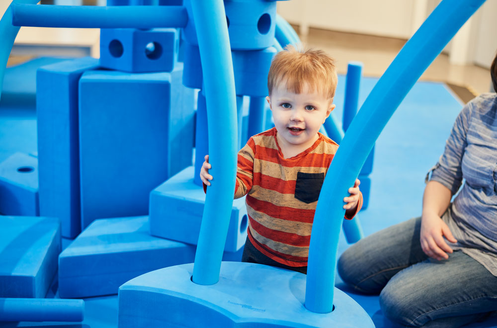 Child with big blue foam blocks