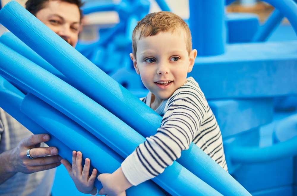 Child with big blue foam blocks