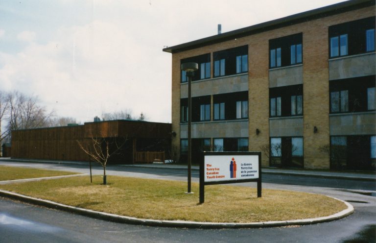 A three-storey brick building with many windows. A sign in front reads “The Terry Fox Canadian Youth Centre.”"alt="A three-storey brick building with many windows. A sign in front reads “The Terry Fox Canadian Youth Centre."